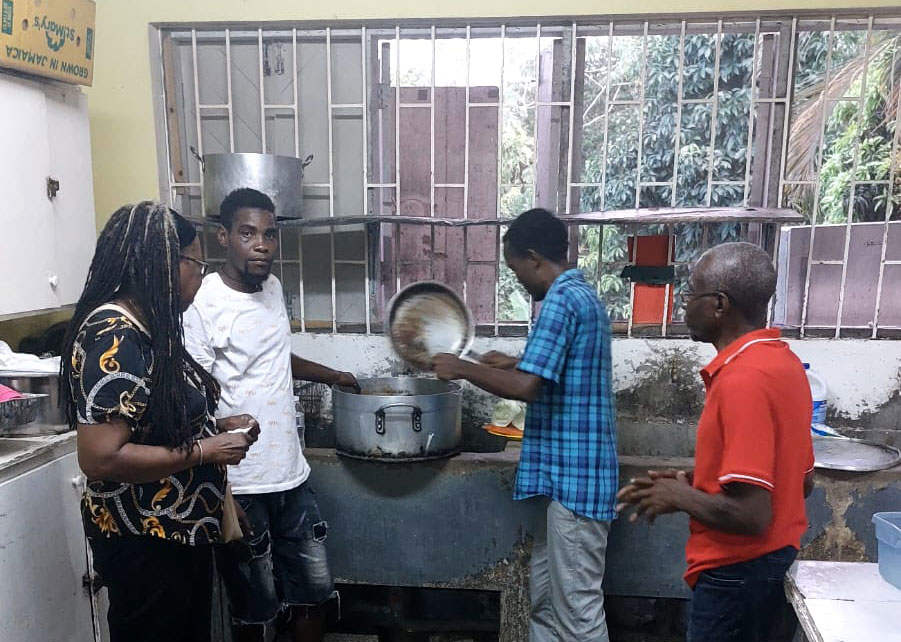 Several of the Haitian migrants in St. Mary preparing lunch in the kitchen provided by the Lay Magistrates in St. Mary