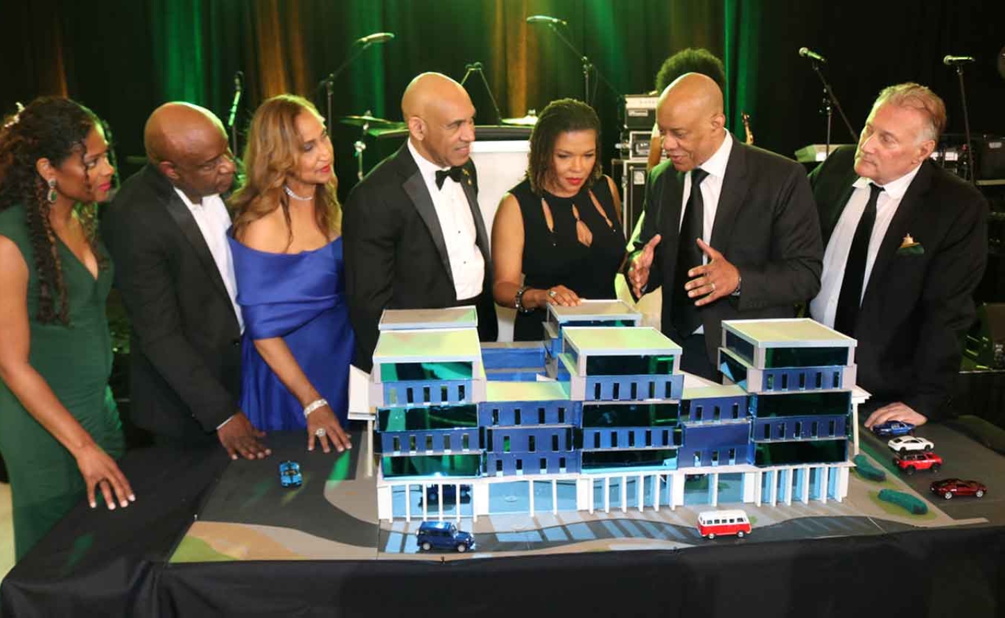 Jamaica’s Ambassador to the United States, Major General (Ret’d) Antony Anderson (fourth left) Stands beside former Ambassador to the United States and MP for Northeast Manchester, Audrey Marks, as they listen attentively to Architect Christopher Carter explaining the prototype for a full replacement hospital to be built in Southeast Manchester by Right Now For Jamaica (RNFJ) organization. Looking on from left  are RNFJ Director Dr. Mikki Lake, RNFJ Vice President, Dr. Maurice Miles, RNFJ Director Dr. Trudy Hall and at the end is RNFJ President Ronald McKay. The prototype was unveiled at RNFJ’s Inaugural Gala, held at the Royal Ballroom in Bowie, Maryland, Saturday, March 28.| Derrick Scott Photo.