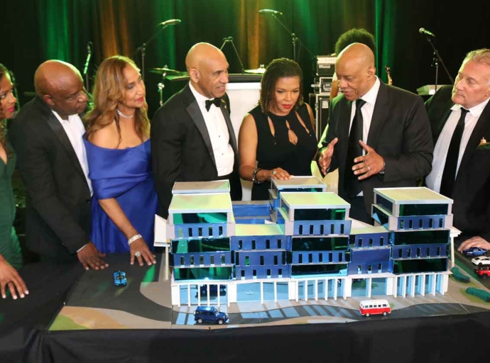Jamaica’s Ambassador to the United States, Major General (Ret’d) Antony Anderson (fourth left) Stands beside former Ambassador to the United States and MP for Northeast Manchester, Audrey Marks, as they listen attentively to Architect Christopher Carter explaining the prototype for a full replacement hospital to be built in Southeast Manchester by Right Now For Jamaica (RNFJ) organization. Looking on from left  are RNFJ Director Dr. Mikki Lake, RNFJ Vice President, Dr. Maurice Miles, RNFJ Director Dr. Trudy Hall and at the end is RNFJ President Ronald McKay. The prototype was unveiled at RNFJ’s Inaugural Gala, held at the Royal Ballroom in Bowie, Maryland, Saturday, March 28.| Derrick Scott Photo.
