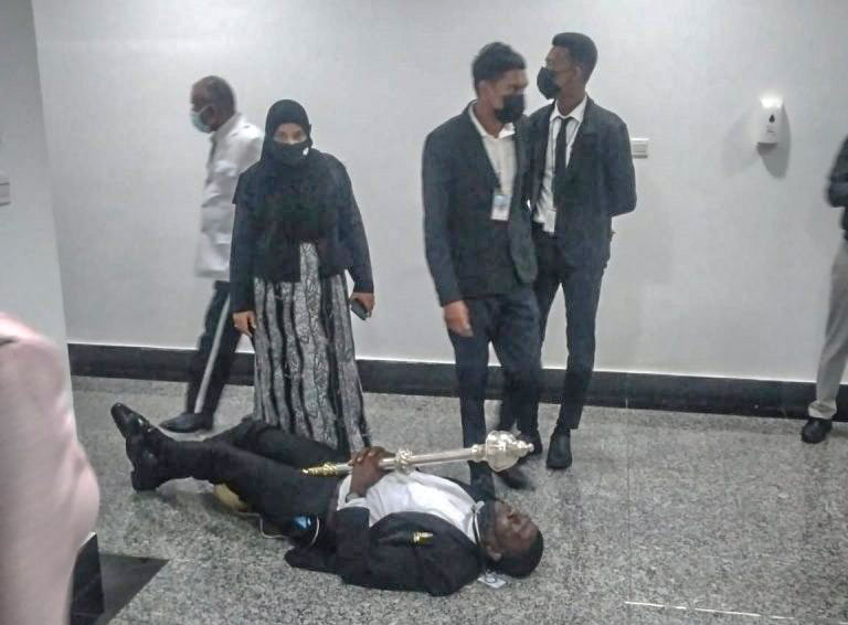 An officer of the Parliament clutching the Mace on the floor as he tries to prevent it from being spirited away by the Opposition