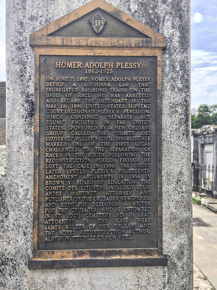 This June 3, 2018 photo shows a marker on the burial site for Homer Plessy at St. Louis No. 1 Cemetery in New Orleans. Homer Plessy, the namesake of the U.S. Supreme Court's 1896 "separate but equal" ruling, was granted a posthumous pardon, Wednesday, Jan. 5, 2022. The Creole man of color died with a conviction still on his record for refusing to leave a whites-only train car in New Orleans in 1892. (AP Photo/Beth J. Harpaz, File)