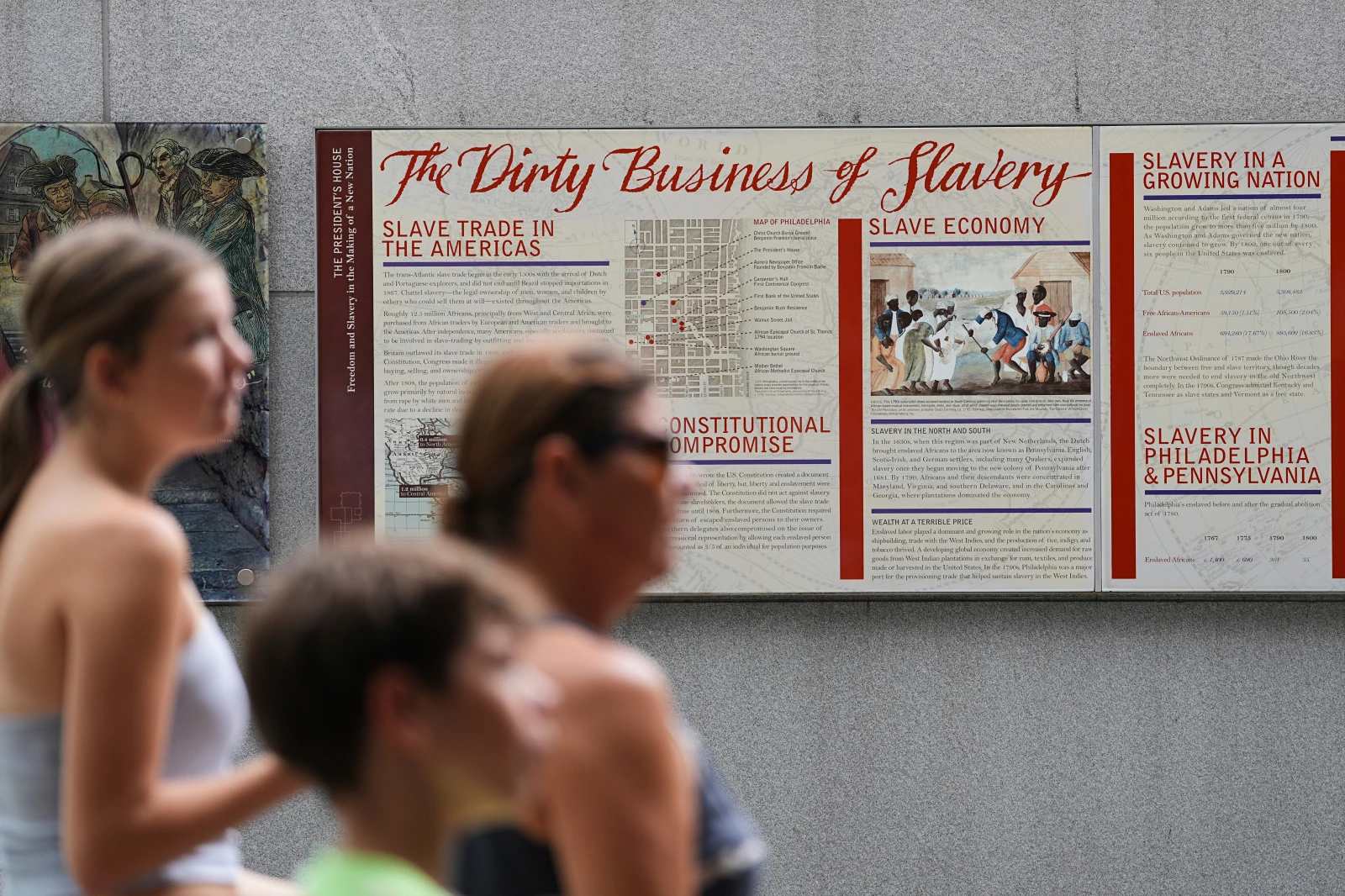 People walk past an informational panel at President’s House Site Tuesday, Aug. 19, 2025, in Philadelphia. (AP Photo/Matt Rourke, File)