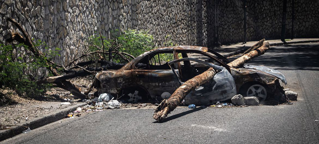 © Giles Clarke A burned car serves as a barricade on a street in Port-au-Prince. With over 150 gangs operating in and around the country, all roads in and out of Haiti's capital are now under some form of gang control.