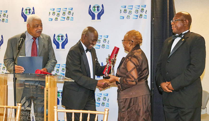 Retired Judge of the Court of Canadian Citizenship, Dr Pamela Appelt accepts an award from NCUIDF Foundation Board Chairman Dr. Bertram Melbourne. Looking on from left is NCUIDF Board member Milton Morris and president of the Northern Caribbean University Dr. Lincoln  Edwards, at the launch of the Northern Caribbean University’s International Development Foundation (NCUIDF) on Sunday April 28, at the Atrium Sligo Seventh Day Adventist Church at Takoma Park Maryland.