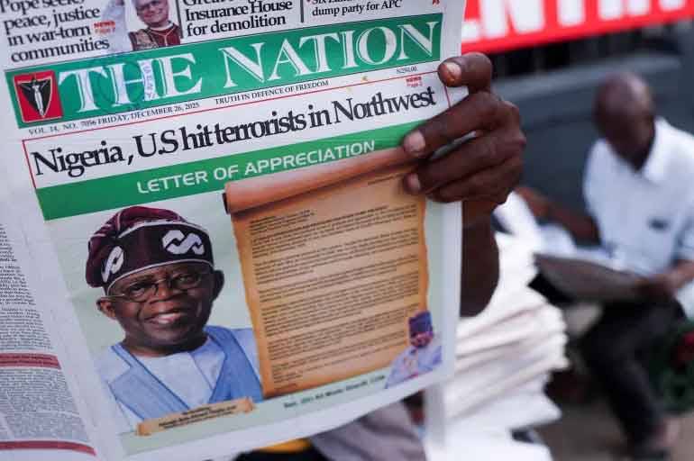 People read newspapers reporting on US air strikes against ISIL (ISIS) fighters in Nigeria, according to US President Donald Trump and the US military, in Lagos, Nigeria, December 26, 2025 [Sodiq Adelakun/Reuters]