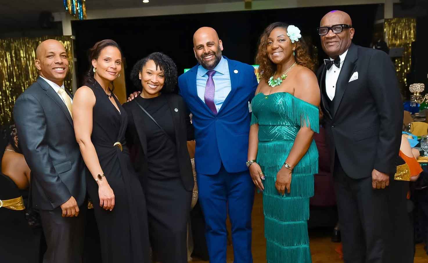 Hartford Mayor Arunan Arulampalam (center) and West Hartford Councilwoman Lisa Lazarus (third left) share a light moment with Gordon Ellison (second left), husband of Embassy of Jamaica Security Attaché2rd left  Tanisha Ellison; President of the Jamaica Nurses Association of New Jersey Celia O’Gilvie; and  2026 Community service awardee Information Attaché Derrick Scott at WISCOH’s 76th Anniversary Gala